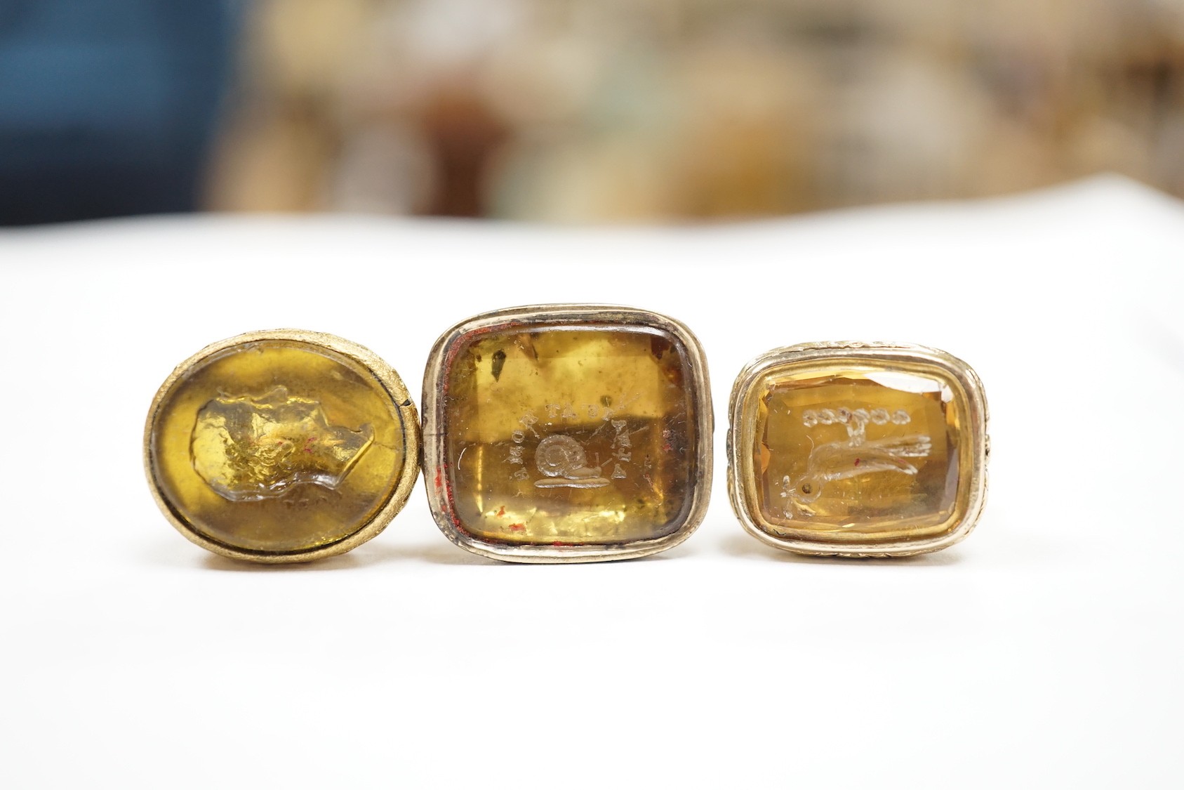 Four assorted 19th century gold plated fob seals, set with citrine, glass or carnelian, largest 30mm.